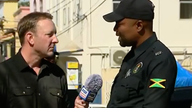 Ray speaks with police officer.